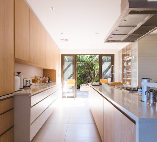 modern open concept kitchen with wall cut out and patio access