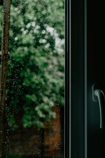 Glass storm door with raindrops on pane