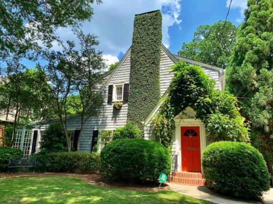 landscaped cottage with red front entry door 